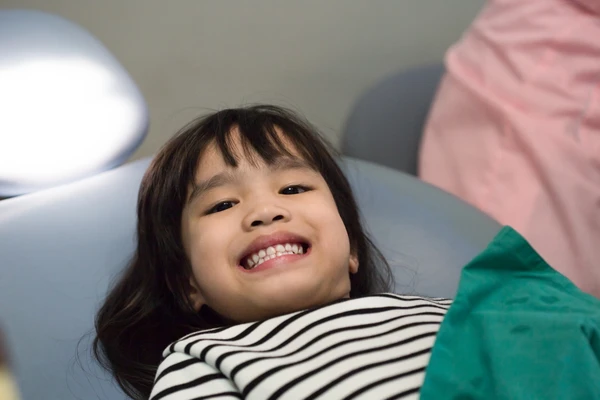 Little girl patient teeth on white at the dentist's office